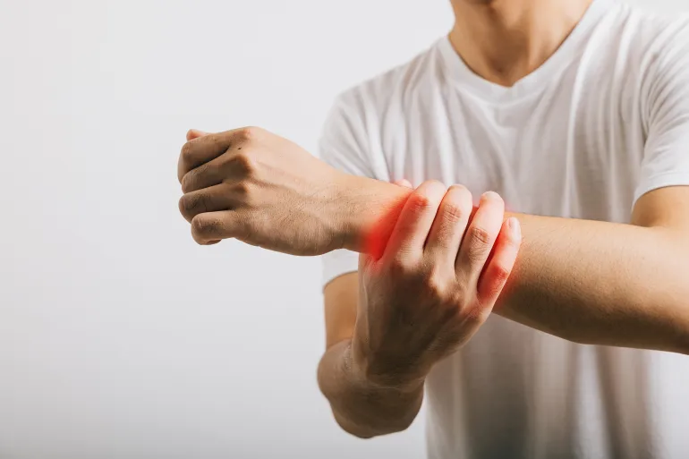 An Asian man with a sad expression endures wrist pain, likely stemming from carpal tunnel syndrome. Studio shot isolated on white, emphasizing health care and medical awareness.; Shutterstock ID 2488541417; purchase_order: aj; job: ; client: ; other: