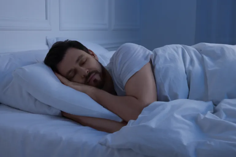 Handsome man sleeping in bed at night
