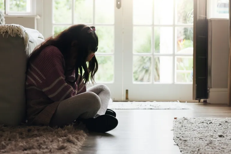Sad, child and crying on the floor in home with mental health, abuse or anxiety from trauma. Crisis, unhappy and girl kid with depression from loneliness, bullying victim or emotional burnout from stress