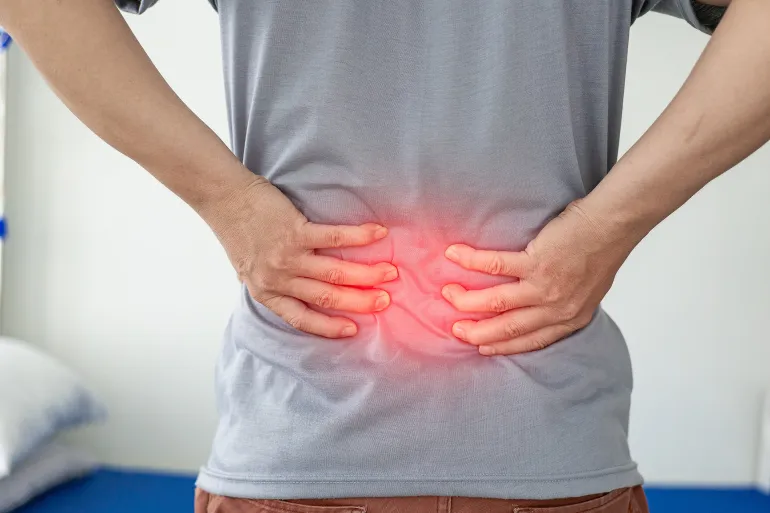 Office Syndrome: Man touching lower back at pain point with red notes, back and waist pain. Asian man touching back with musculoskeletal pain. Close-up photo; Shutterstock ID 2423644323; purchase_order: aj; job: ; client: ; other:
