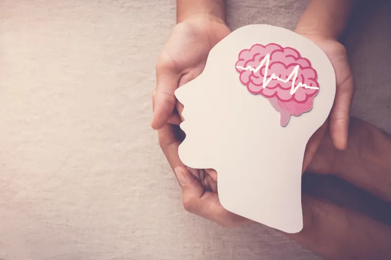 Adult and child hands holding encephalography brain paper cutout, autism, Stroke, Epilepsy and alzheimer awareness, seizure disorder, stroke, ADHD, world mental health day concept