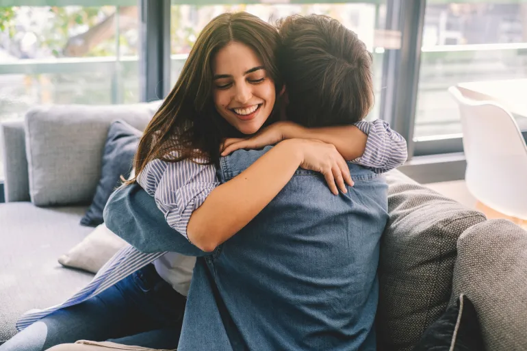 Beautiful young couple hugging in their new apartment. Engaged couples celebrate by hugging each other happily for their new home.