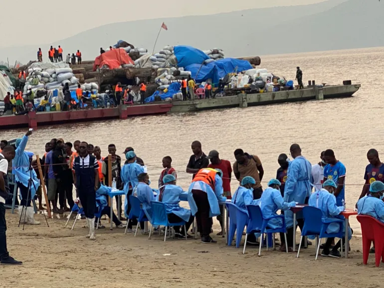 Passengers who disembarked from a boat intercepted by health authorities wait to be tested following the death of a passenger suspected of having Ebola, in Kinshasa, Democratic Republic of the Congo, August 6, 2026. Authorities said the passenger had disembarked earlier in the city. REUTERS/Benoit Nyemba