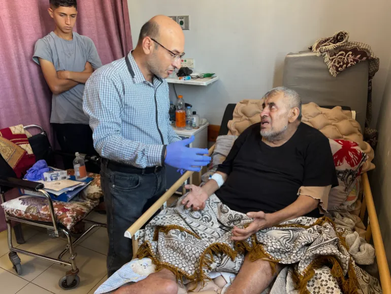 Palestine - Gaza - Al-Shifa Hospital - Photographed by Yasser Al-Banna - Exclusive Al-Jazeera Net: Doctor Bassam Al-Masry, head of the burn surgery department at Al-Shifa Hospital in Gaza, inspects one of the wounded who has burns and needs surgery.