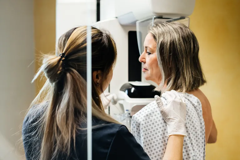 A nurse provides assistance to a patient undergoing a mammogram in a modern medical facility. The image highlights the importance of early detection and compassionate care in healthcare.